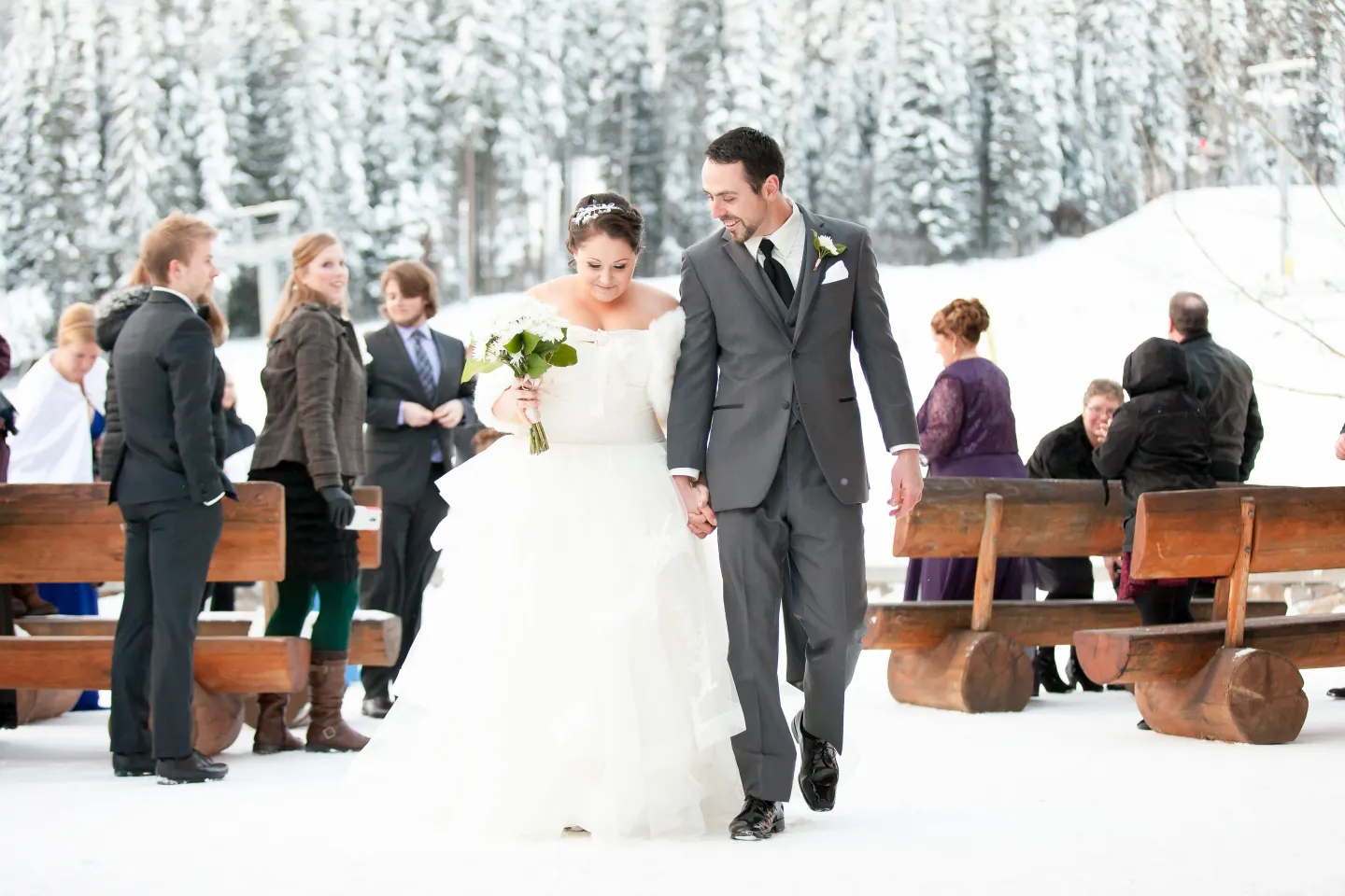 A wedding ceremony takes place outside in winter at a ski resort