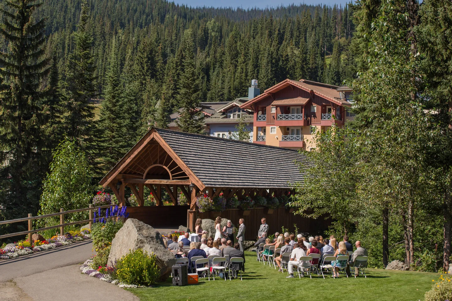 An outdoor wedding ceremony by a covered bridge