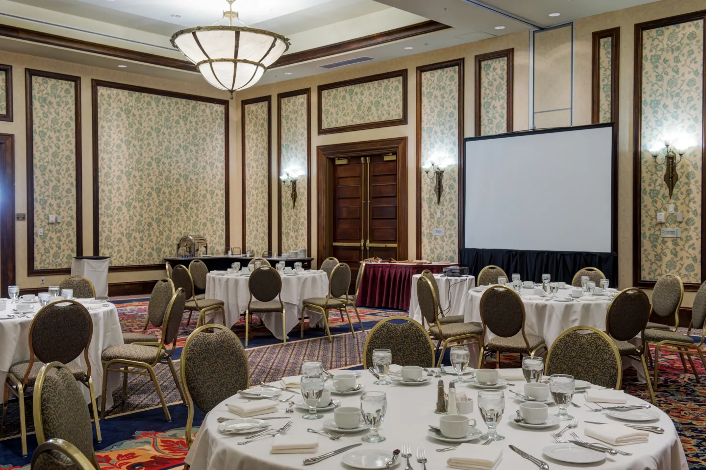 A grand hotel ballroom set with round dining tables