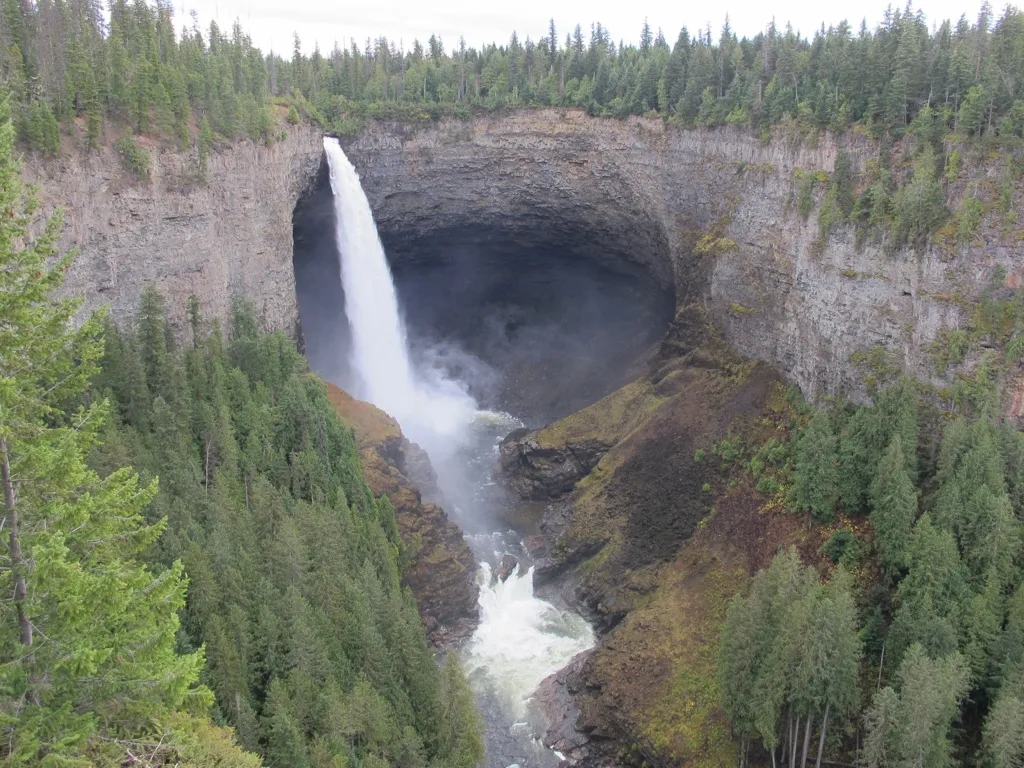 A view of a waterfall flowing over a cliff and down a valley