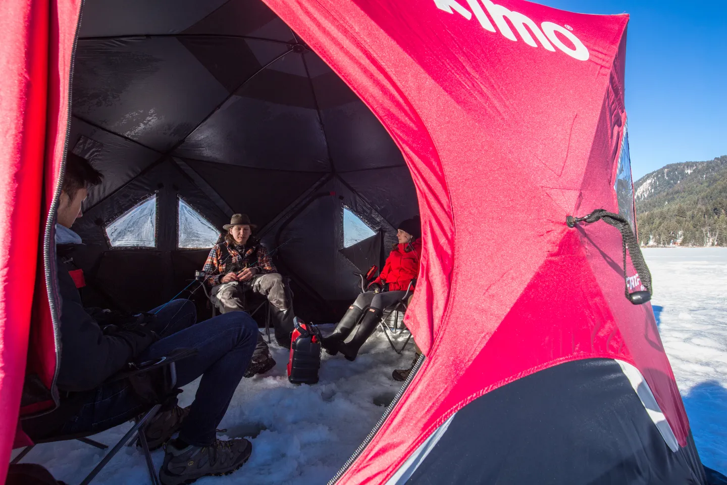 People ice fishing under a tent