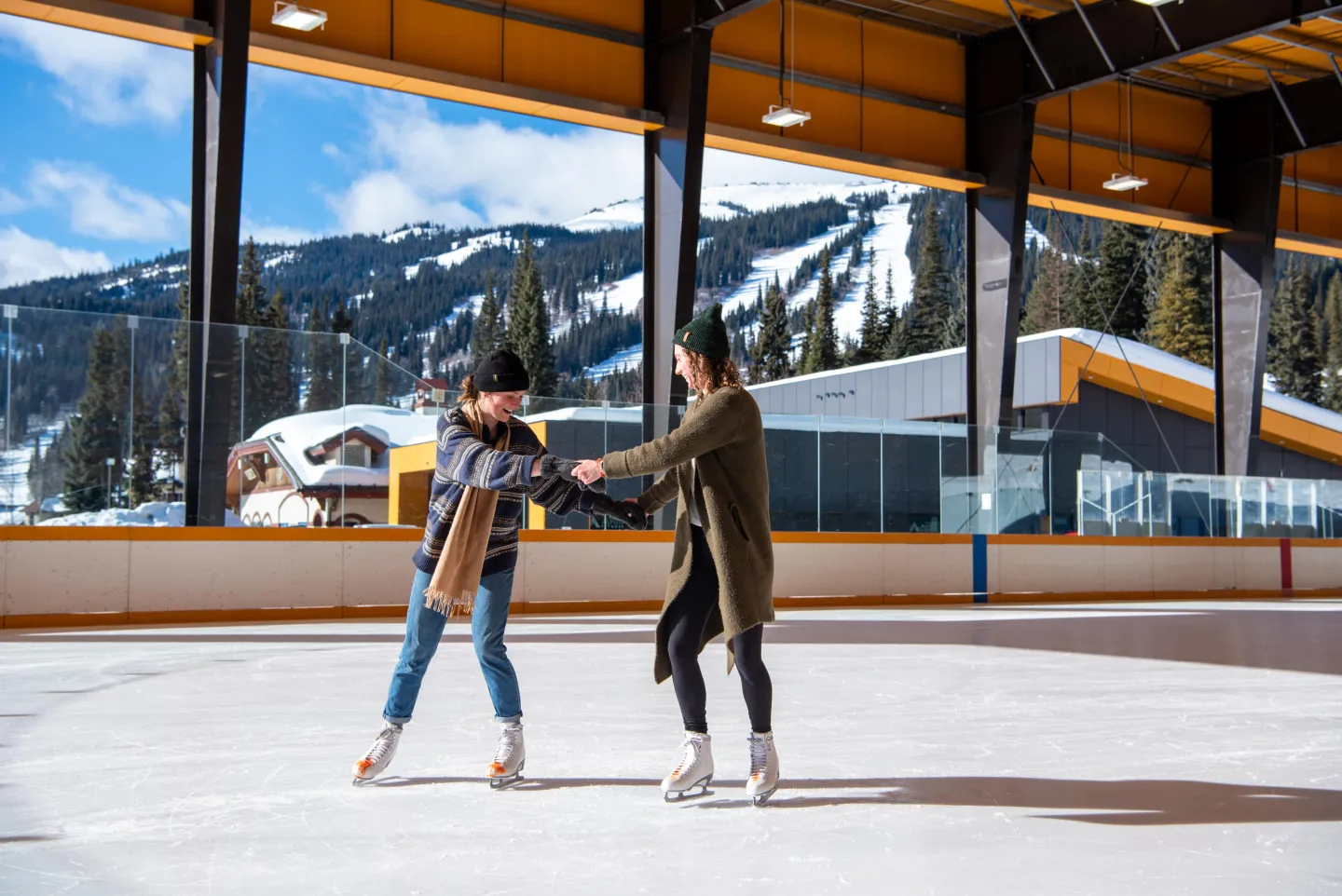 Two women skating with mountain views