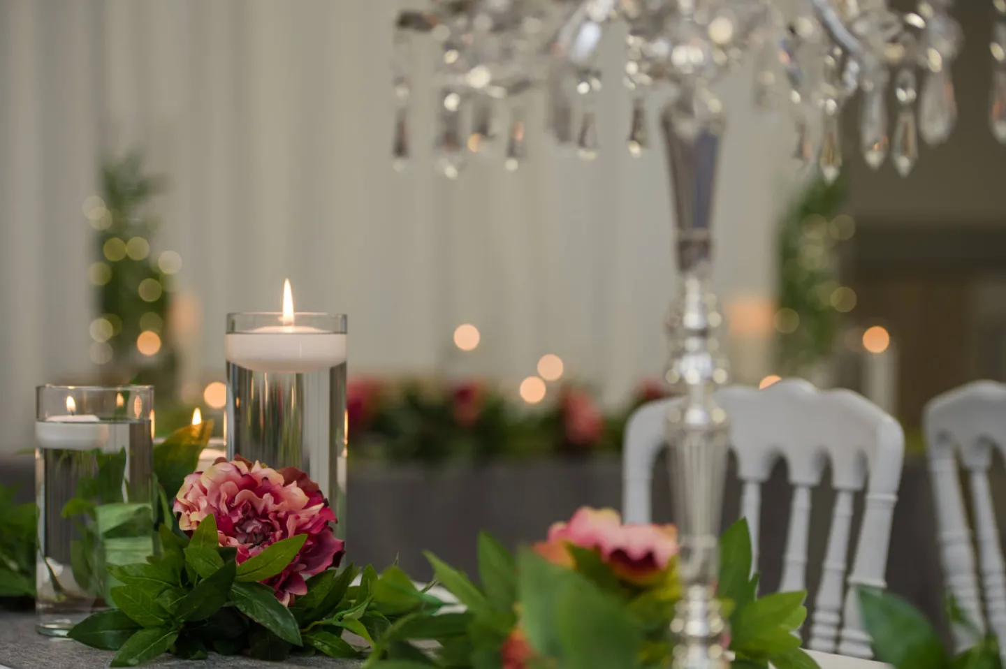 Candles and flowers set up on a table with lights and chairs