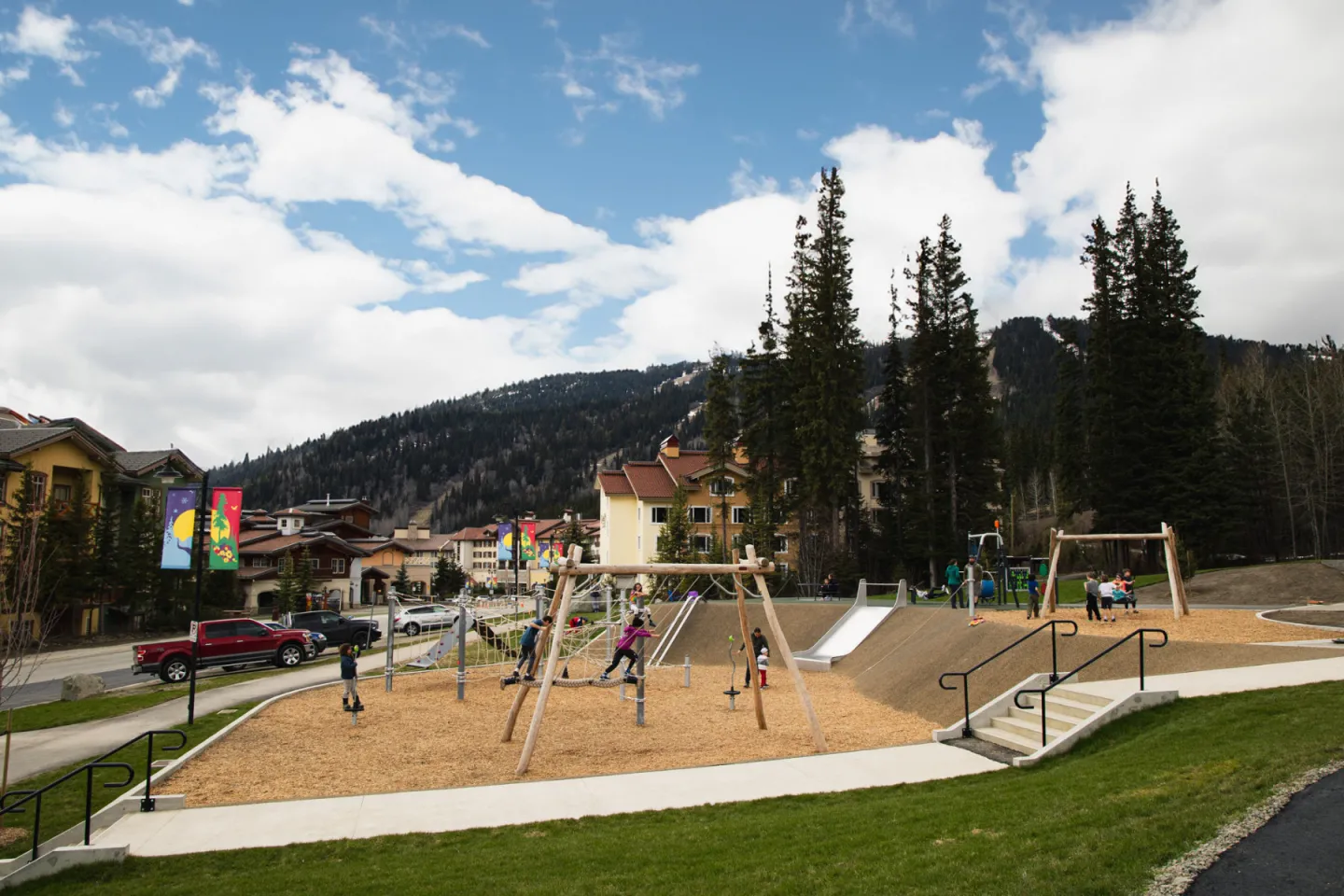 Playground with swings and slides with mountains in the background