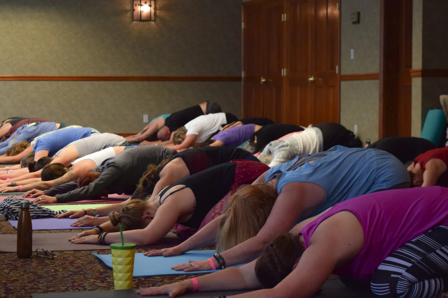 Group of people doing yoga poses in a room