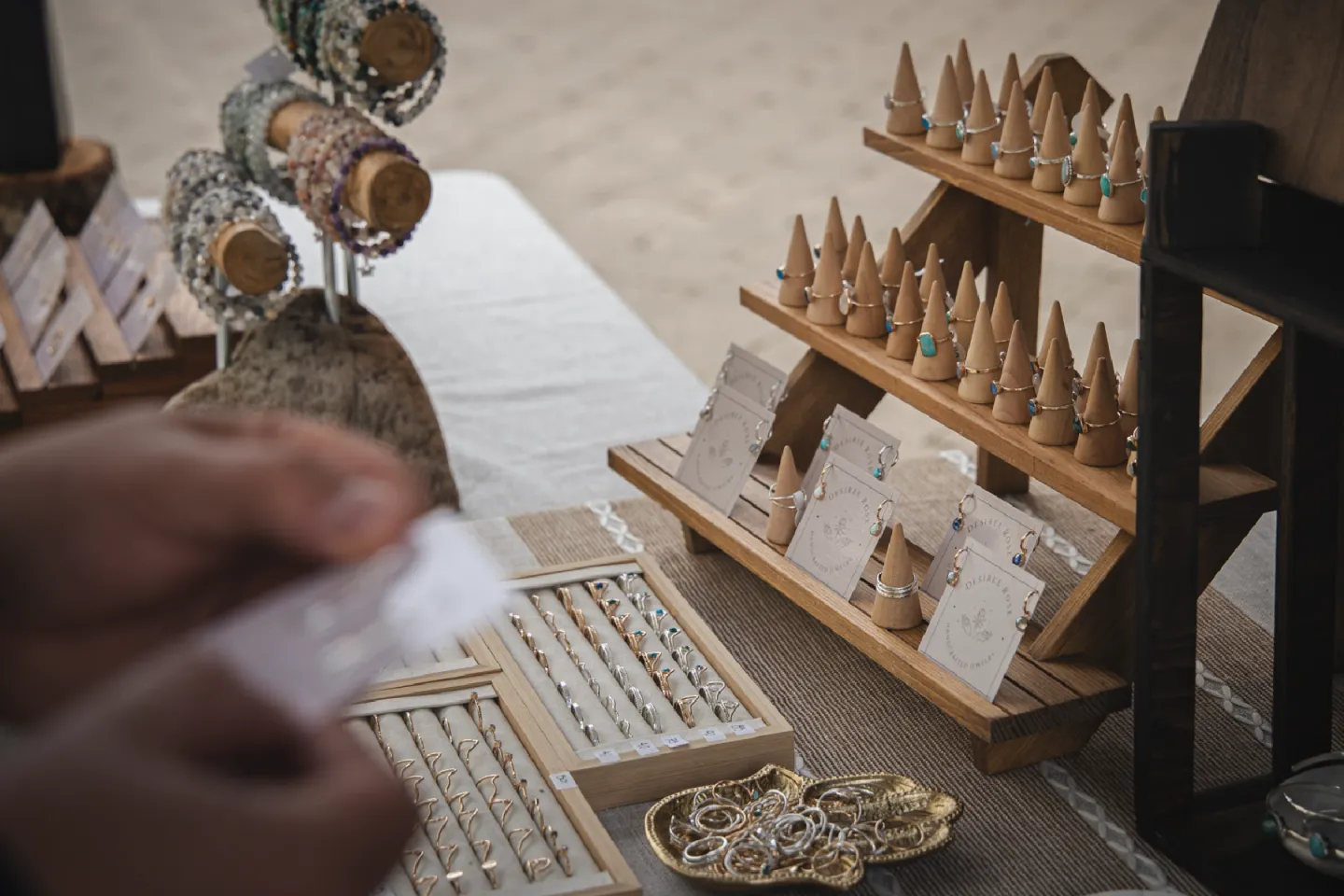 Jewelry display with rings and bracelets on a market table.