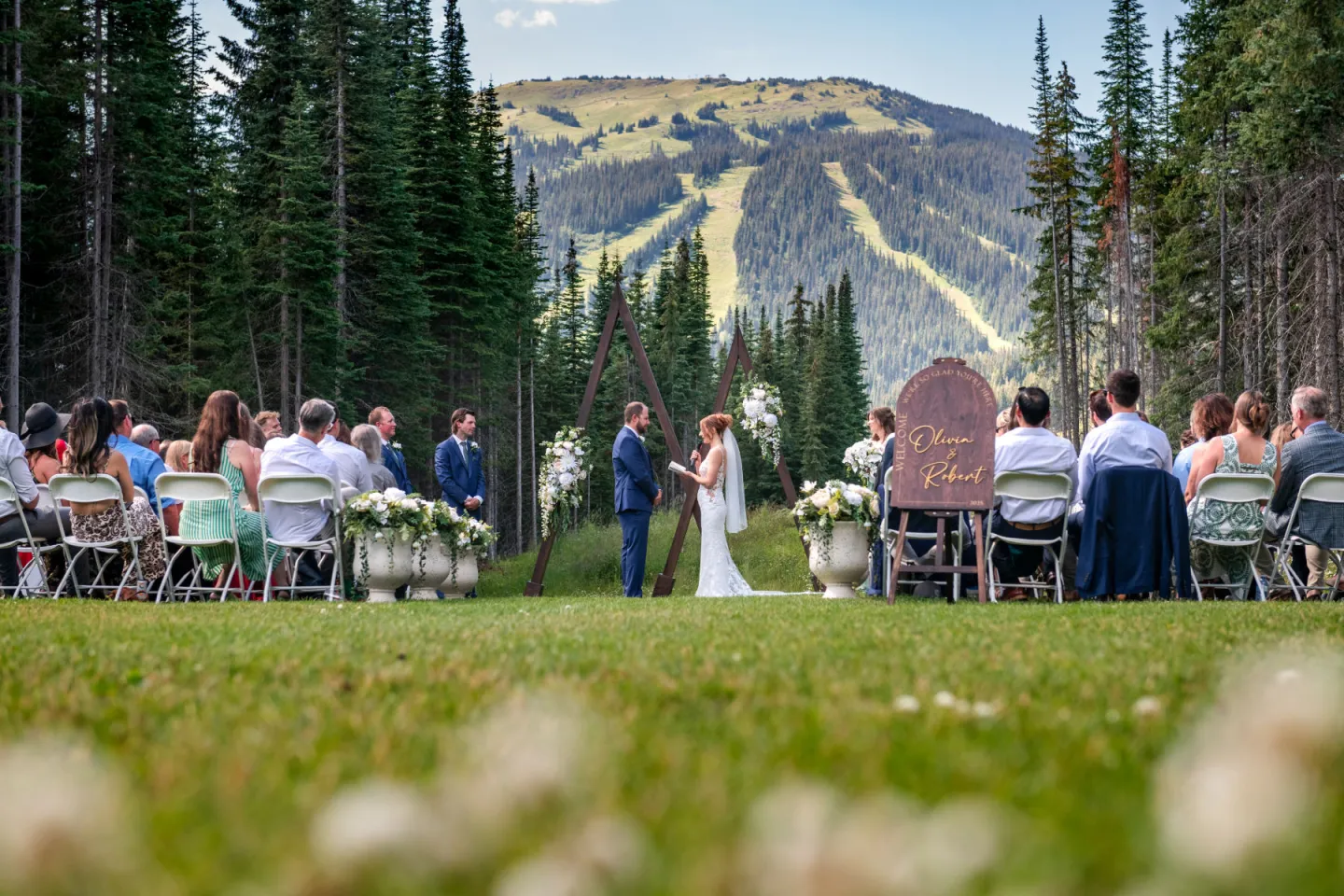 Outdoor wedding ceremony in a scenic mountain setting.